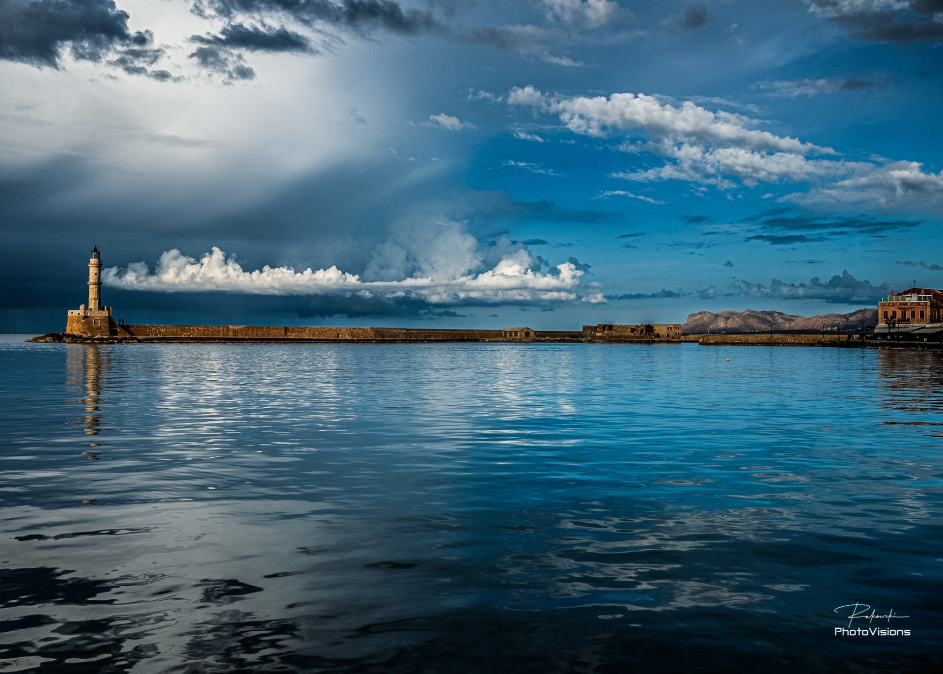 The Venetian lighthouse and harbour of Chania beneath a dramatic sky